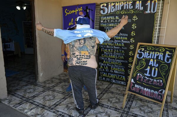 Производитель пиццы Гильермо Родригес, крещенный в церкви Марадоны, демонстрирует татуировку на спине, Мерло, Аргентина - Sputnik Молдова