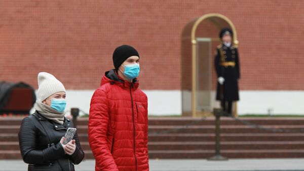 Люди в защитных масках в Александровском саду в Москве - Sputnik Moldova-România