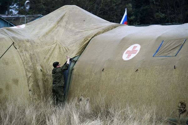 Российская военнослужащая закрепляет тент на каркасном модуле на территории мобильного полевого госпиталя неподалеку от Степанакерта - Sputnik Moldova