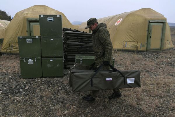 Российский военнослужащий выгружает оборудование на территории мобильного полевого госпиталя неподалеку от Степанакерта - Sputnik Moldova