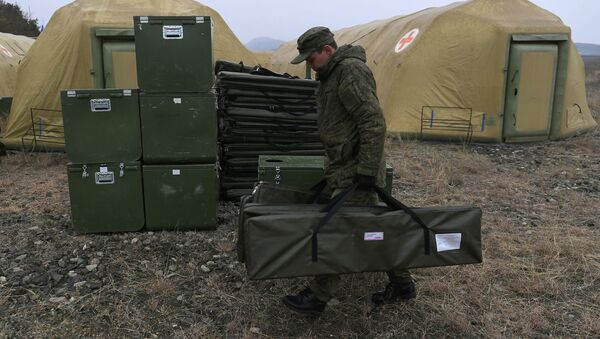 Российский военнослужащий выгружает оборудование на территории мобильного полевого госпиталя неподалеку от Степанакерта - Sputnik Moldova
