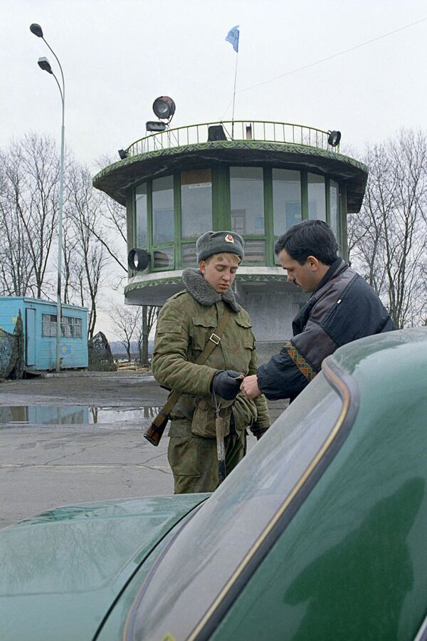 Солдат российских миротворческих сил проверяет автотранспорт на въезде в город Бендеры во время конфликтов в Приднестровье. - Sputnik Молдова
