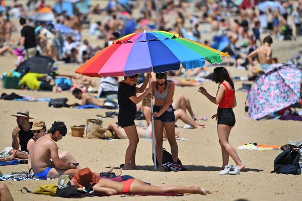 Люди наслаждаются теплой погодой на пляже Сент-Килда в Мельбурне - Sputnik Moldova