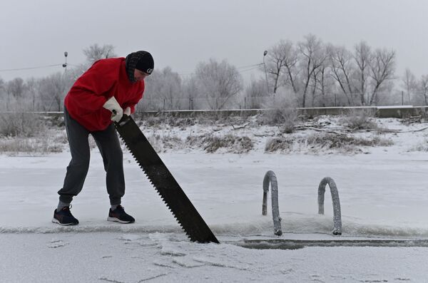 Мужчина рубить прорубь на реке Иртыш во время открытия сезона зимнего плавания в Омске, Россия - Sputnik Moldova-România