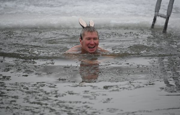 Мужчина в ледяной воде реки Иртыш во время открытия сезона зимнего плавания в Омске, Россия - Sputnik Moldova-România