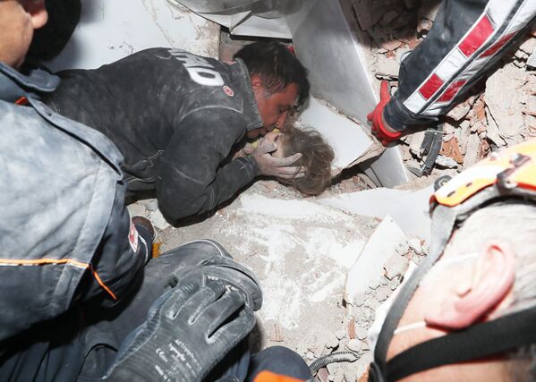 In this photo provided by the government's Search and Rescue agency AFAD, rescue workers, who were trying to reach survivors in the rubble of a collapsed building, surround Ayda Gezgin in the Turkish coastal city of Izmir, Turkey, Tuesday, Nov. 3, 2020, as they pull the young girl out alive from the rubble of a collapsed apartment building four days after a strong earthquake hit Turkey and Greece. The girl, Ayda Gezgin, was seen being taken into an ambulance on Tuesday, wrapped in a thermal blanket, amid the sound of cheers and applause from rescue workers. - Sputnik Молдова