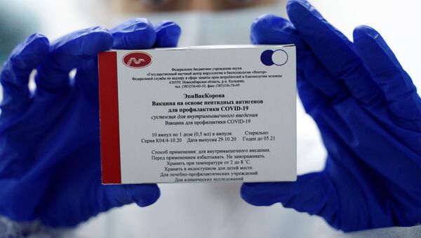 Медработник демонстрирует вакцину ЭпиВакКорона в процедурном кабинете - Sputnik Молдова