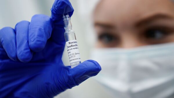 Медработник демонстрирует вакцину ЭпиВакКорона в процедурном кабинете - Sputnik Молдова