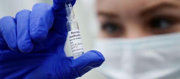 Медработник демонстрирует вакцину ЭпиВакКорона в процедурном кабинете - Sputnik Молдова