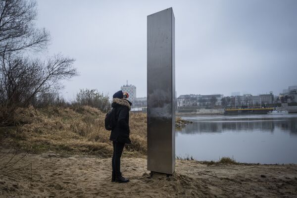 Женщина у металлического монолита, появившийся на берегу Вислы в столице Польши Варшаве - Sputnik Молдова