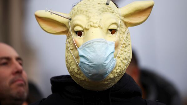 Un om mascat participă la demonstrația anti-vaccinare în Piața Parlamentului din Londra - Sputnik Moldova-România