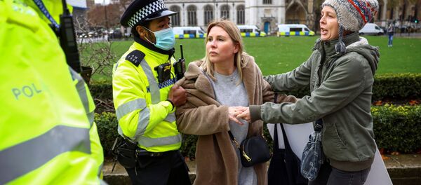 Полицейский пытается задержать активистку демонстрации против вакцинации в Лондоне Полицейский пытается задержать активистку демонстрации против вакцинации в Лондоне - Sputnik Moldova-România