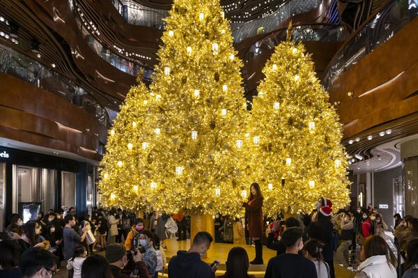 Люди фотографируются перед Золотыми рождественскими елками в торговом центре в Гонконге - Sputnik Молдова