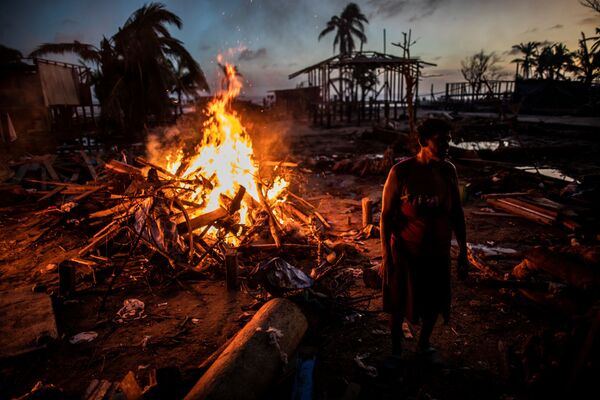 Люди сжигают мусор, оставшийся после урагана Йота в Бильви, Никарагуа - Sputnik Moldova-România