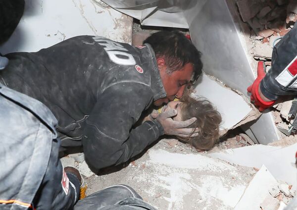 Турецкие спасатели вытаскивают ребенка из под обломков после землетрясения в Измире - Sputnik Молдова
