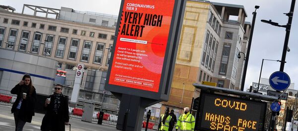 Pedestrians walk past a British government health information advertisement highlighting new restrictions amid the spread of the coronavirus disease (COVID-19), London, Britain - Sputnik Moldova