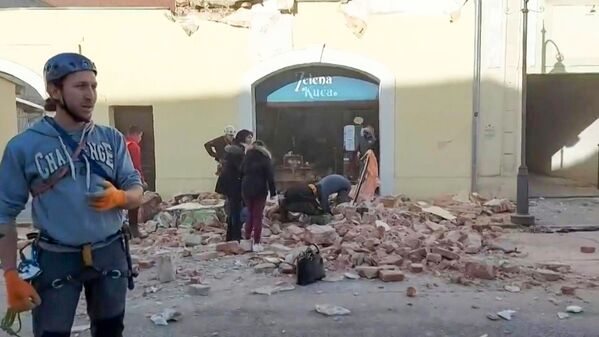 A grab of a video taken and released by the Croatian Red Cross on December 29, 2020 shows people looking through the rubbles and rescuing victims in the streets of Petrinja, after the town was striked by an earthquake of 6,4 magnitude. - The tremor, one of the strongest to rock Croatia in recent years, collapsed rooftops in Petrinja, home to some 20,000 people, and left the streets strewn with bricks and other debris. Rescue workers and the army were deployed to search for trapped residents, with no casualties initially reported.  - Sputnik Молдова