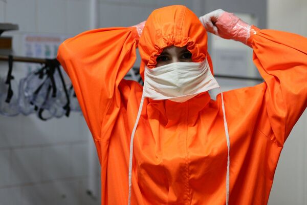 Для безопасности медицинские работники полностью экипируются. Облачаются в комбинезоны, надевают маски, перчатки. - Sputnik Молдова
