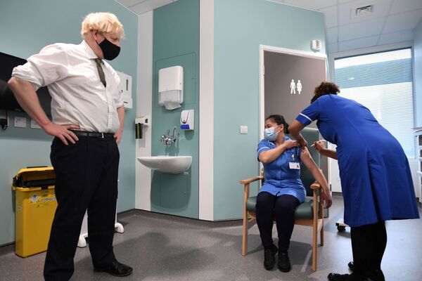 Премьер-министр Великобритании Борис Джонсон наблюдает за вакцинацией во время своего визита в больницу Chase Farm на севере Лондона - Sputnik Moldova-România