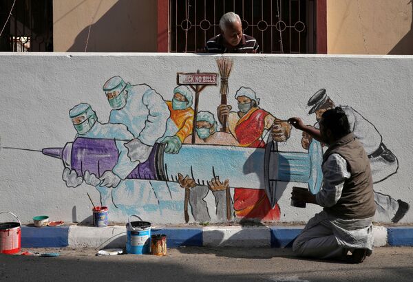 Мужчина рисует граффити, изображающее вакцину от COVID-19, в Калькутте, Индия - Sputnik Moldova