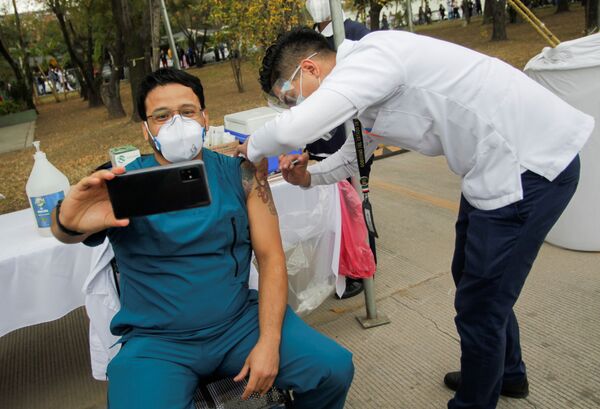 Медицинский работник делает селфи во время инъекции вакцины отCOVID-19 в военном госпитале в Сан-Николас-де-лос-Гарса, Мексика - Sputnik Moldova-România