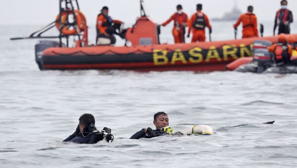 Водолазы ВМС Индонезии вытаскивают часть самолета из воды во время операции по поиску пассажирского самолета Sriwijaya Air, который упал в море недалеко от Джакарты, Индонезия. - Sputnik Moldova