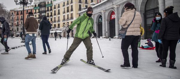 Мужчина едет на горных лыжах по одной из улиц в Мадриде - Sputnik Молдова