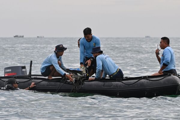Водолазы ВМС Индонезии собирают обломки рейса Sriwijaya Air SJY182 во время поисково-спасательной операции в море недалеко от острова Ланканг  - Sputnik Молдова