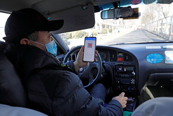 Водитель такси показывает QR-код регистрации здоровья пассажиру для сканирования перед поездкой в Пекине - Sputnik Moldova