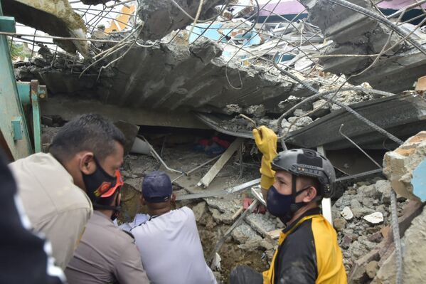 Спасатели ищут выживших в больнице, разрушенной землетрясением в городе Мамаджу, Индонезия - Sputnik Moldova-România