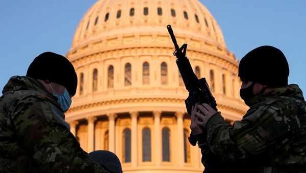 Член Национальной гвардии США получает оружие у здания Капитолия в городе Вашингтон  - Sputnik Молдова
