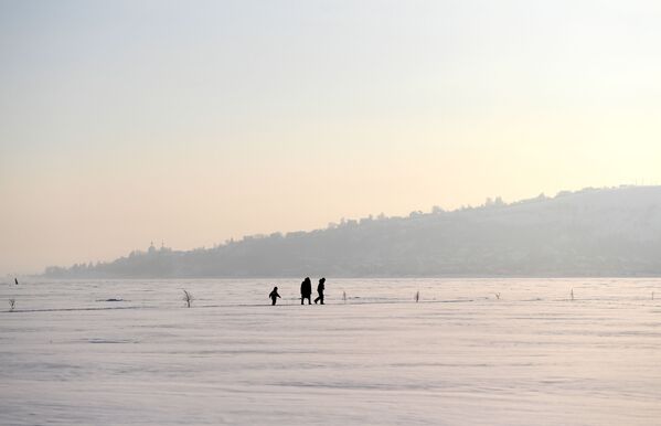 Женщина с детьми гуляют по льду реки Волги - Sputnik Молдова