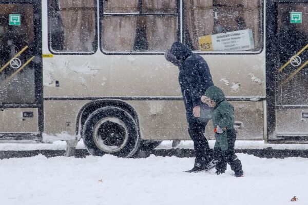 Женщина с ребенком во время снегопада на улице Краснодара - Sputnik Молдова