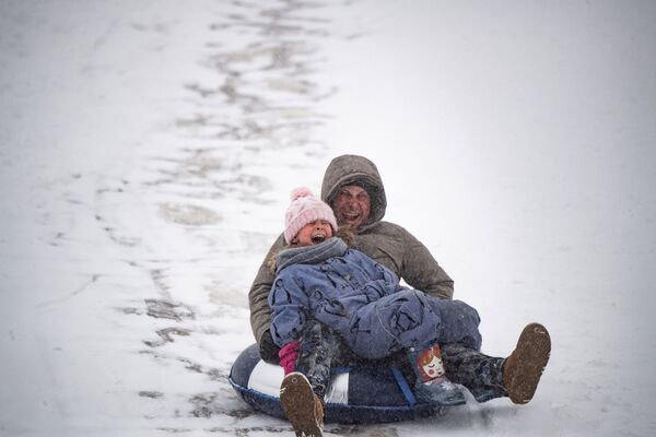 Папа с ребенком катаются с горки в парке Ходынское поле в Москве - Sputnik Молдова