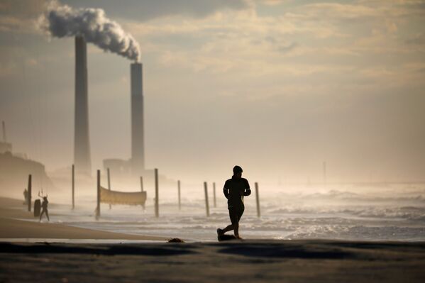 Мужчина бежит по пляжу в Ашкелоне во время третьего локдауна в Израиле - Sputnik Moldova-România