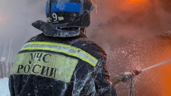 Сотрудник пожарной службы тушит пожар - Sputnik Молдова