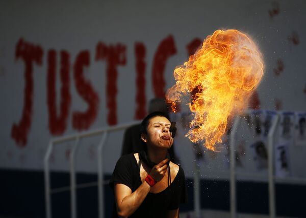 Активистка плюет огненными шарами во время акции протеста перед зданием Генеральной прокуратуры в Мехико, Мексика - Sputnik Молдова