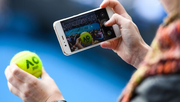 Зритель фотографирует на свой мобильный телефон во время финального матча в четырнадцатый день Открытого чемпионата Австралии по теннису  - Sputnik Молдова