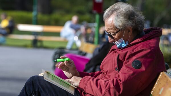 Пожилой мужчина в медицинской маске во время отдыха в одном из парков в Вене - Sputnik Молдова