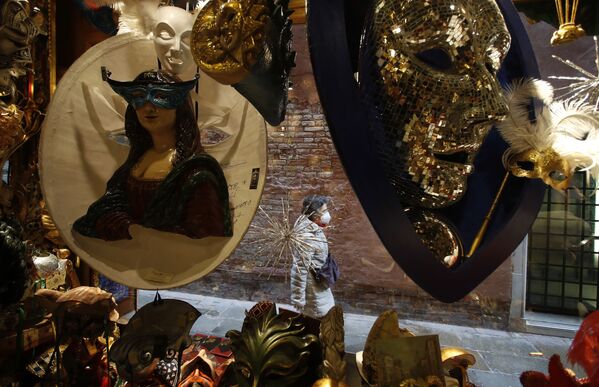 Женщина походит мимо витрины с карнавальными масками в Венеции  - Sputnik Молдова