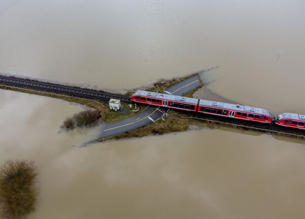 Поезд проезжает по железной дороге на затопленной местности в Германии  - Sputnik Moldova