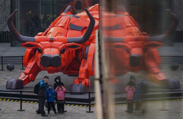 Семья фотографируется перед скульптурой быка в торговом центре в Пекине в преддверии Лунного Нового года - Sputnik Молдова