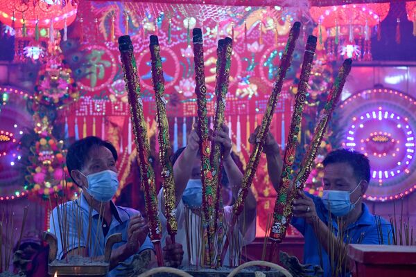 Верующие с ароматическими палочками в храме во время Нового года по лунному календарю в Такмау, Камбоджа - Sputnik Молдова