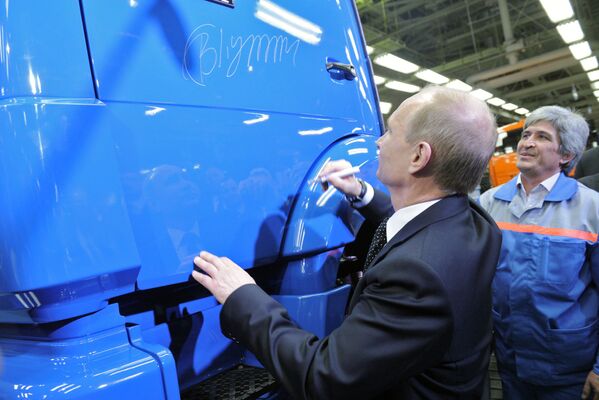 Владимир Путин оставляет автограф на двери грузовика во время посещения завода КамАЗ в Набережных Челнах в Татарстане - Sputnik Молдова