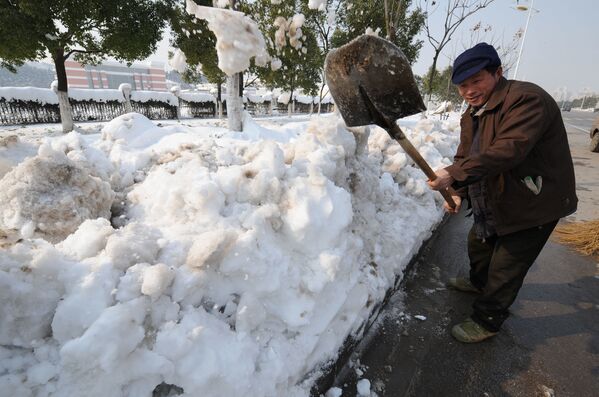 Китайский рабочий чистит улицы от сильного снегопада в Китае, 2008 год  - Sputnik Молдова