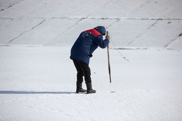 Un pescar sparge gheața pentru a face gaura în care va prinde pește  - Sputnik Moldova