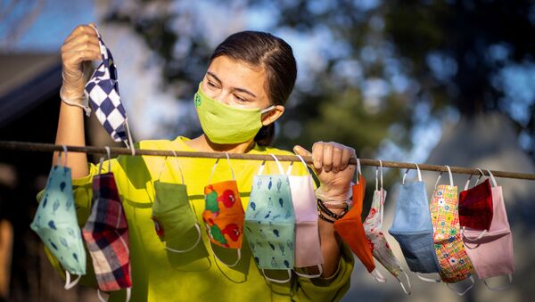 Девушка развешивает защитные маски - Sputnik Молдова