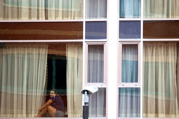 Женщина смотрит из окна отеля Radisson Blu в аэропорту Хитроу, Лондон, Великобритания - Sputnik Молдова