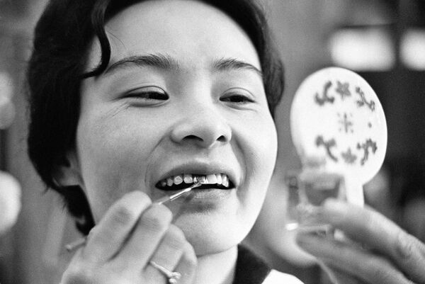 O tânără japoneză își vopsește dinții în culoare neagră, 1966. În vremurile străvechi, femeile își colorau dinții în negru ca semn de frumusețe. Mai târziu, a devenit un obicei doar pentru femeile căsătorite. - Sputnik Moldova