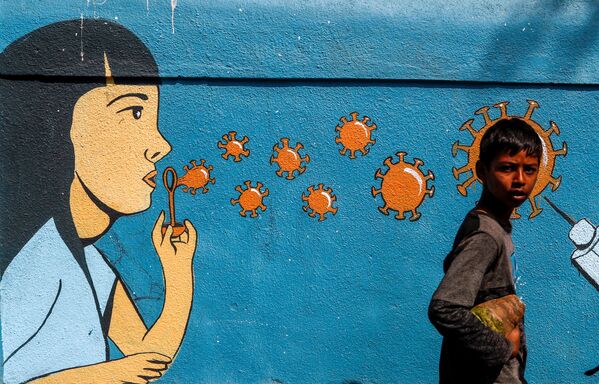 Мальчик проходит мимо граффити в Мумбаи, Индия - Sputnik Молдова